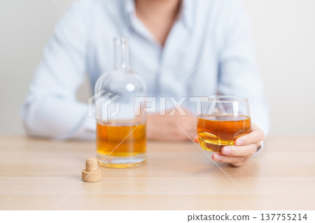 man with glass of whiskey on table, suffering from alcohol addiction and alcoholism concept. depicting emotional distress, depression, substance abuse problem, unhealthy lifestyle and mental health man with glass of whiskey on table, suffering from alcohol addiction and alcoholism concept. depicting emotional distress, depression, substance abuse problem, unhealthy lifestyle and mental health 137755214