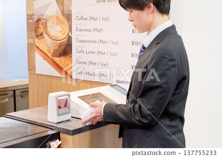 一名商務人士正在自助結帳櫃檯掃描商品條碼。 137755233