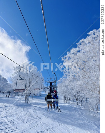 Skiers riding the ski lift at Nozawa Onsen Ski Resort Skiers riding the ski lift at Nozawa Onsen Ski Resort 137755325