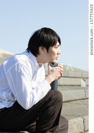 一名男子在廣場的階梯上休息。 一名男子在廣場的階梯上休息。 137755829