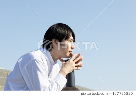 A man resting on a stepped riverbank. A man resting on a stepped riverbank. 137755830