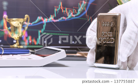 Gloved Hand Presenting Gold Bar with Trophy and Market Screen 137755887