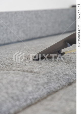 Vacuuming grey carpet in a modern room during daylight hours Vacuuming grey carpet in a modern room during daylight hours 137756261