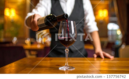 Pouring a glass of red wine from a bottle 137756742