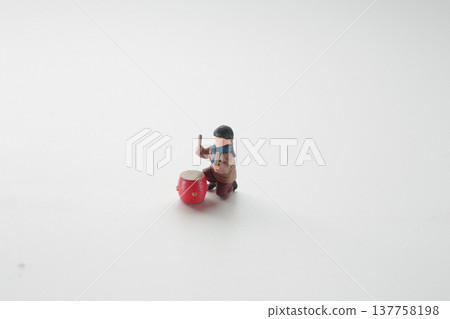 Miniature Figure Kneeling Beside Bright Red Festival Drum 137758198