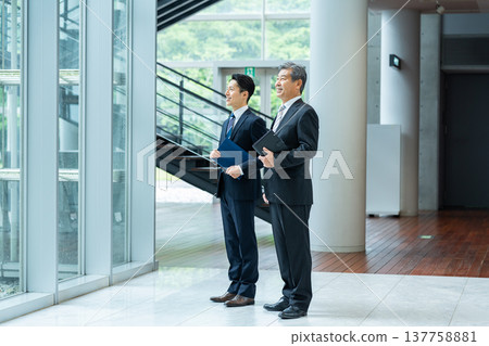Business people standing in the office corridor Business people standing in the office corridor 137758881