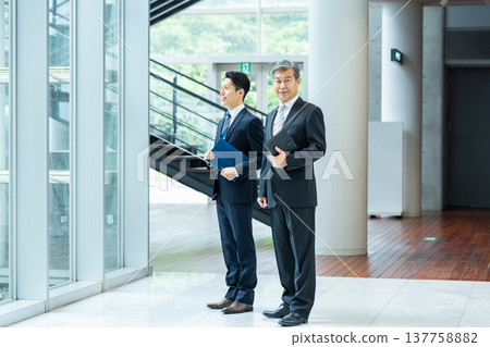 站在辦公室走廊的商務人士 站在辦公室走廊的商務人士 137758882
