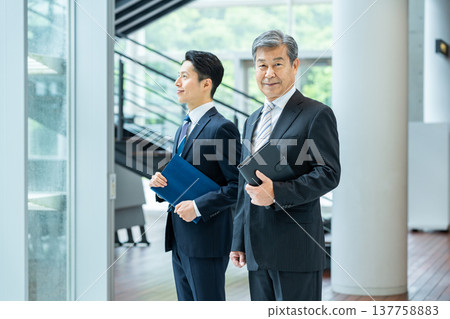 站在辦公室走廊的商務人士 站在辦公室走廊的商務人士 137758883