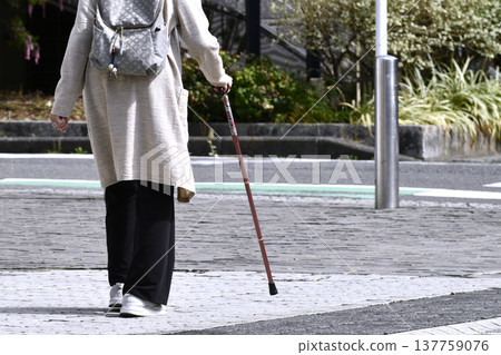 在日本橫濱，一位拄著拐杖（戴著口罩）的老婦人艱難地走在崎嶇不平的人行道上……人生究竟是怎樣一番景象？ = 橫濱市 137759076