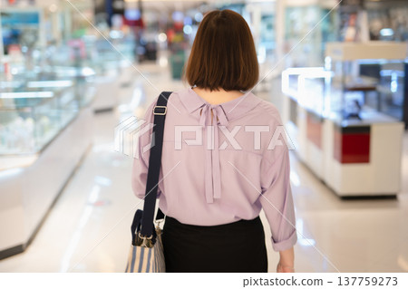 backside of short hair asian woman shopping at mall during sale and discount with wear protective mask backside of short hair asian woman shopping at mall during sale and discount with wear protective mask 137759273