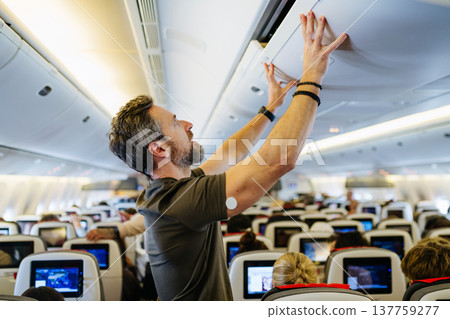 Passenger with diabetes placing carry on luggage in overhead compartment. 137759277