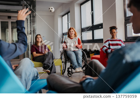 Teen students talking together in inclusive school setting. Teen students talking together in inclusive school setting. 137759359