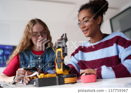 High school students working on robotics project. Girls in STEM. 137759367