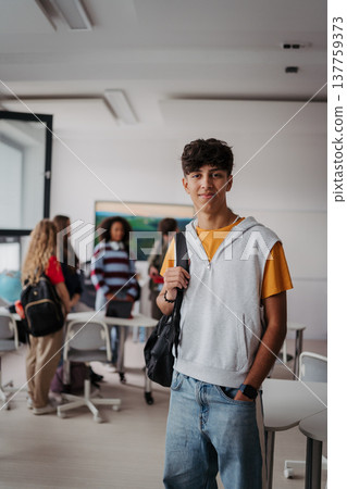 Confident teen student standing in modern classroom. Confident teen student standing in modern classroom. 137759373