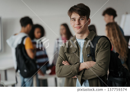 Confident teen student standing in modern classroom. 137759374