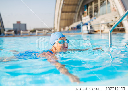 Elderly woman enjoying sport swimming for vitality and longevity. 137759455