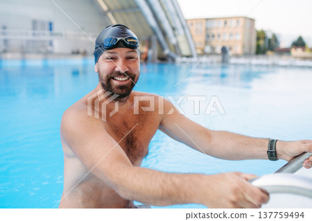 Male swimmer getting out of the pool after swim training. 137759494