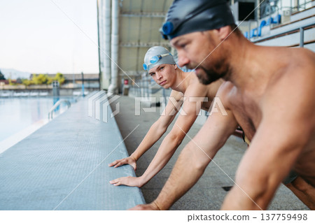 Father and teenage son enjoying swim training together. Father and teenage son enjoying swim training together. 137759498