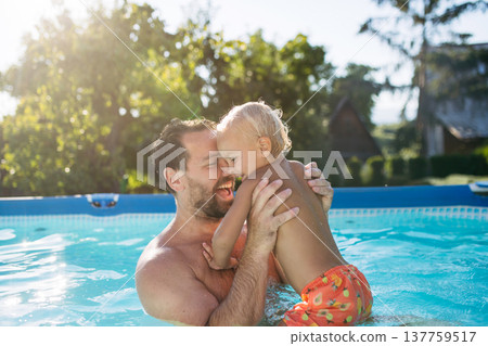 Father playing with little son in pool. 137759517