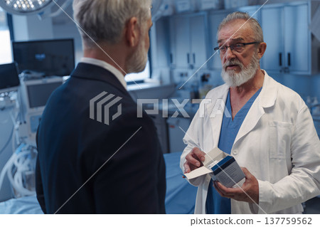 Medical sales representative presenting new medication to doctor. Medical sales representative presenting new medication to doctor. 137759562