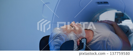 Male patient undergoing CT scan examination in hospital. 137759580