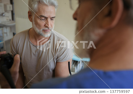 Doctor explaining colonoscopy results to patient using monitor images. Doctor explaining colonoscopy results to patient using monitor images. 137759597