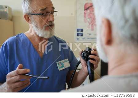 Doctor explaining colonoscopy results to patient using monitor images. Doctor explaining colonoscopy results to patient using monitor images. 137759598