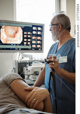 Doctor looking at monitior during gastroscopy procedure, examining upper digestive tract. Doctor looking at monitior during gastroscopy procedure, examining upper digestive tract. 137759604