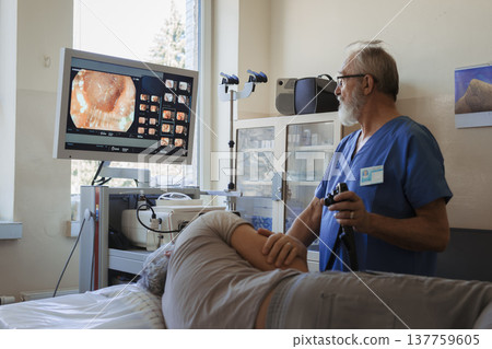 Doctor looking at monitior during gastroscopy procedure, examining upper digestive tract. 137759605