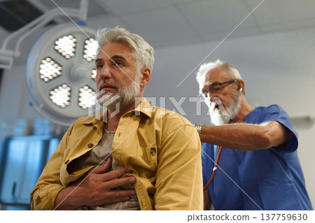 Doctor examining patient, listening to breathing with stethoscope. Doctor examining patient, listening to breathing with stethoscope. 137759630
