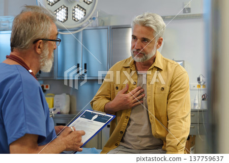 Patient explaing his health issues to older doctor. Patient explaing his health issues to older doctor. 137759637