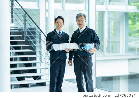 Businessmen in work clothes having a meeting at the site Businessmen in work clothes having a meeting at the site 137760084