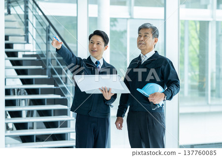 Businessmen in work clothes having a meeting at the site Businessmen in work clothes having a meeting at the site 137760085