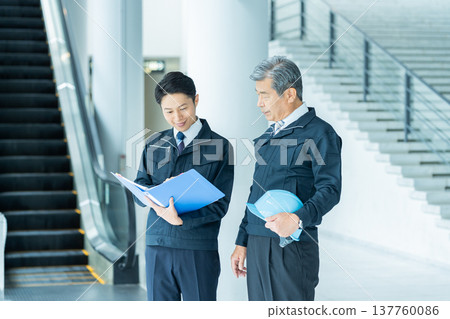 穿著工作服的商人在現場開會 穿著工作服的商人在現場開會 137760086