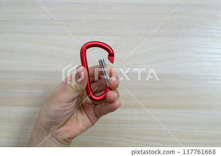 手中拿著一個紅色鋁製登山扣 137761668