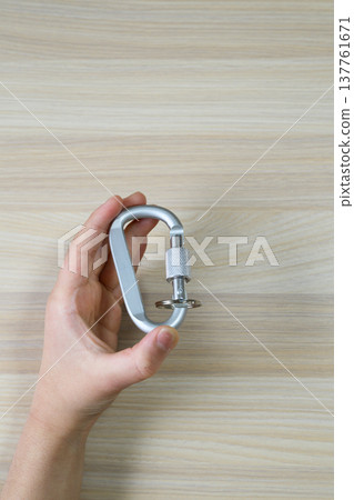 手中拿著一個銀色登山扣，旁邊有一大片空白。 137761671