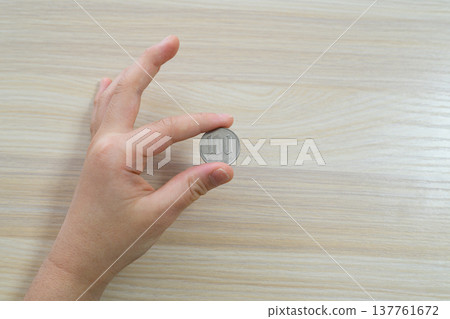 特寫鏡頭：一手用指尖撿起一枚100日圓硬幣。 137761672