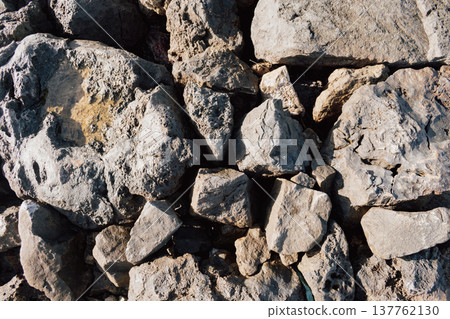 Dry ancient limestone rocks texture background pattern under harsh summer sunlight and shadows Dry ancient limestone rocks texture background pattern under harsh summer sunlight and shadows 137762130