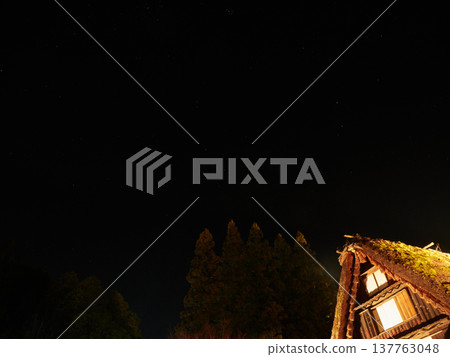 A wintertime view of Gero Gassho Village, a popular tourist spot in Gifu Prefecture, Japan, featuring the night sky and stars. 137763048