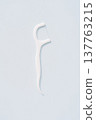Single white dental floss pick isolated on light blue background, minimal oral hygiene concept 137763215