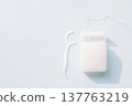 Dental floss container with single floss pick on light blue background, minimal oral hygiene flat lay 137763219