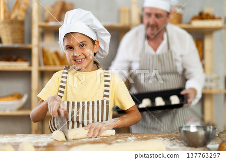 Dad and daughter cook croissants together, cut dough and have nice time Dad and daughter cook croissants together, cut dough and have nice time 137763297