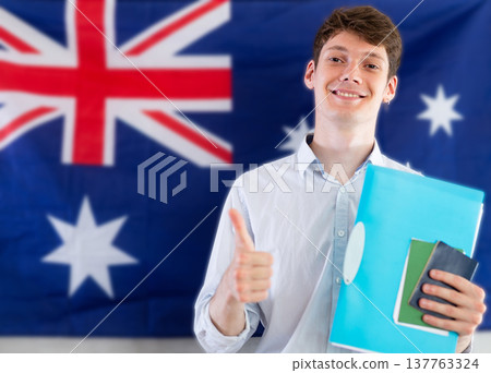 Young guy posing with documents against background of Australian flag 137763324