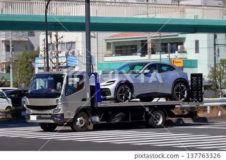 一輛運輸車正在運送一輛跑車 一輛運輸車正在運送一輛跑車 137763326