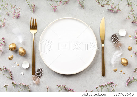 Minimal Easter Table Setting with Golden Eggs and Spring Flowers 137763549