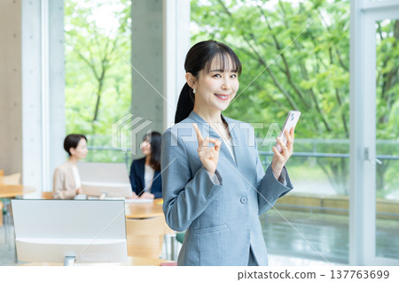 Business woman using a smartphone in the office Business woman using a smartphone in the office 137763699