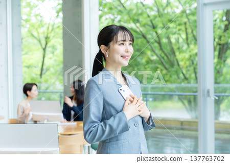 在辦公室使用智能手機的女商人 在辦公室使用智能手機的女商人 137763702