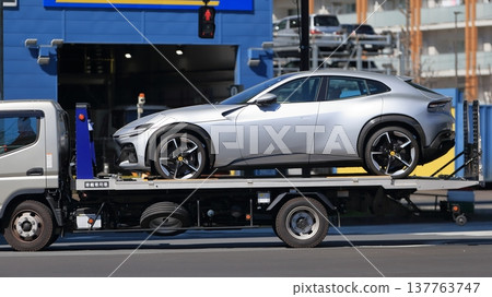 一輛運輸車正在運送一輛跑車 一輛運輸車正在運送一輛跑車 137763747