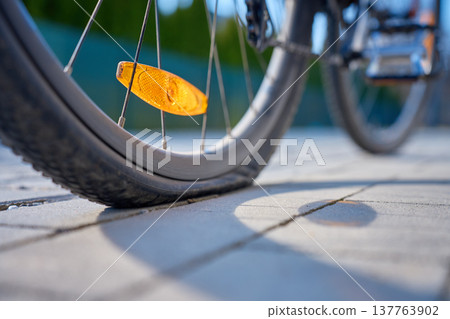 Close up of flat tire on bicycle wheel on pavement 137763902