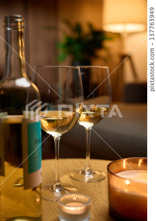 Bottle of white wine with two glasses and candles at home Bottle of white wine with two glasses and candles at home 137763949